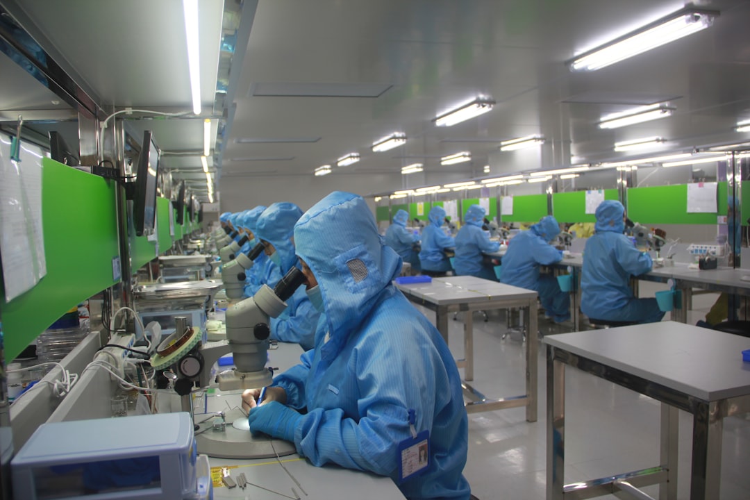 A 3D mascot illustration of two cute factory robots assembling a smartphone next to a glowing semiconductor chip on a conveyor belt, soft purple and gold ambient lighting, friendly atmosphere, Pixar quality 8K, no text, no logos
